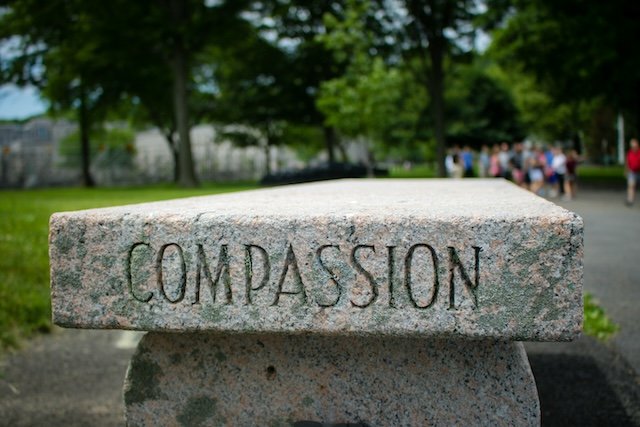 Compassion etched in a stone bench